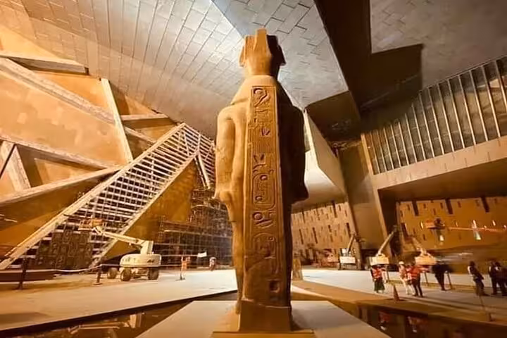 Grand Egyptian Museum interior with towering ancient statue, key highlight on Cairo tour with Giza Pyramids and Sphinx