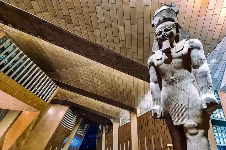 Grand Egyptian Museum entrance with colossal pharaoh statue, highlights on Cairo Giza pyramids tour