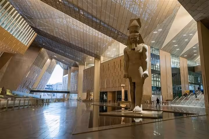 Grand Egyptian Museum atrium in Cairo with colossal pharaoh statue on private guided tour