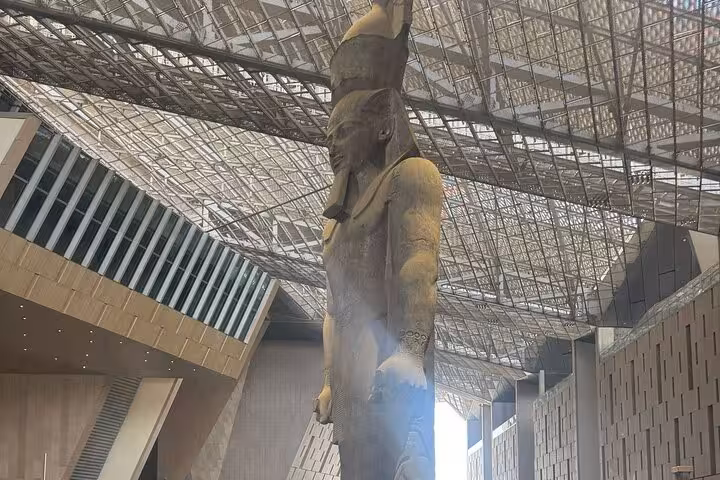 Grand Egyptian Museum Cairo interior featuring a towering ancient Egyptian statue on a private guided tour