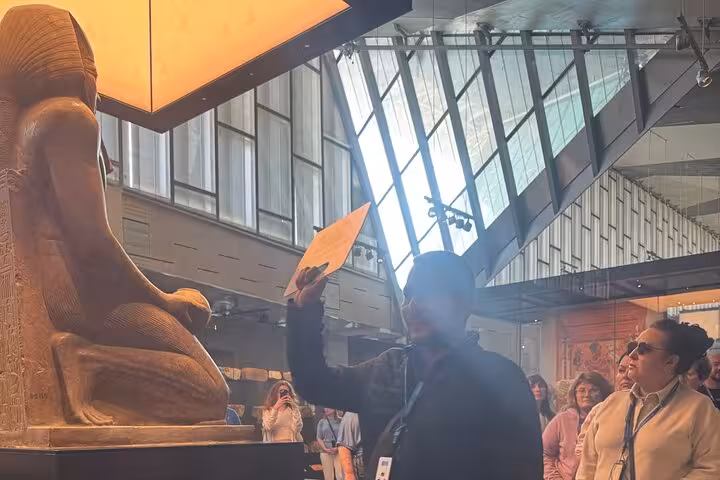 Private Grand Egyptian Museum tour with Egyptologist guide explaining a colossal pharaoh statue in Cairo