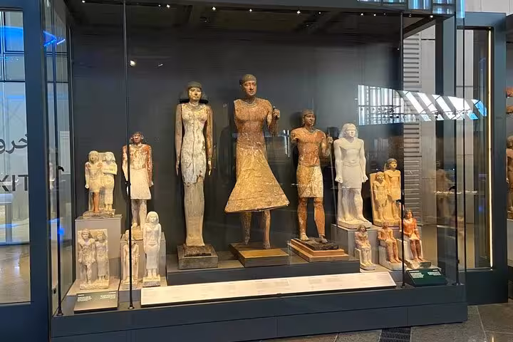 Grand Egyptian Museum gallery display of ancient Egyptian statues, highlight of Giza Pyramids day tour with lunch