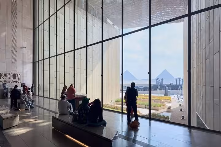 Grand Egyptian Museum lobby with panoramic glass view of Giza Pyramids, half-day tour with lunch and tickets