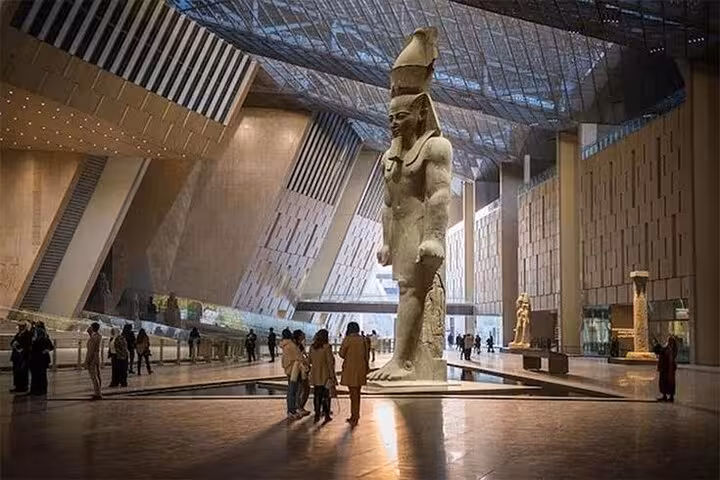 Grand Egyptian Museum tour in Giza with towering pharaoh statue in the main atrium before pyramid visit