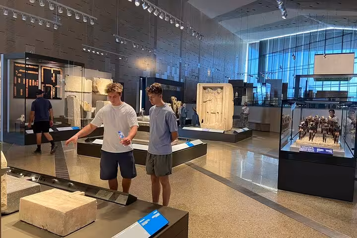 Visitors exploring ancient artifacts inside the Grand Egyptian Museum on a Giza Pyramids day tour with lunch