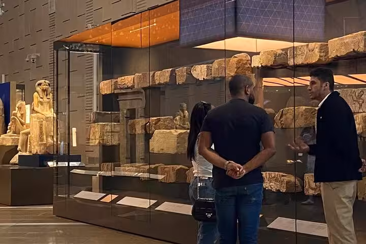 Grand Egyptian Museum gallery with pyramid model and monumental statues, part of Giza Pyramids full-day tour with lunch