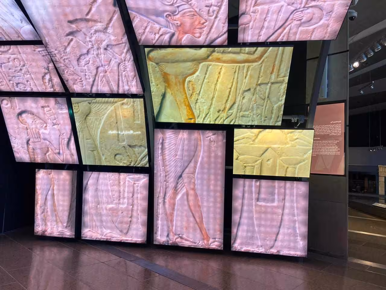 Grand Egyptian Museum digital wall showing ancient Egyptian relief carvings on a full-day Giza tour with lunch
