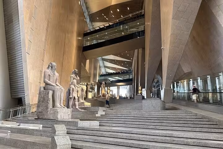 Grand Egyptian Museum grand hall with monumental statues and stairs, must-see stop on Giza Pyramids tour