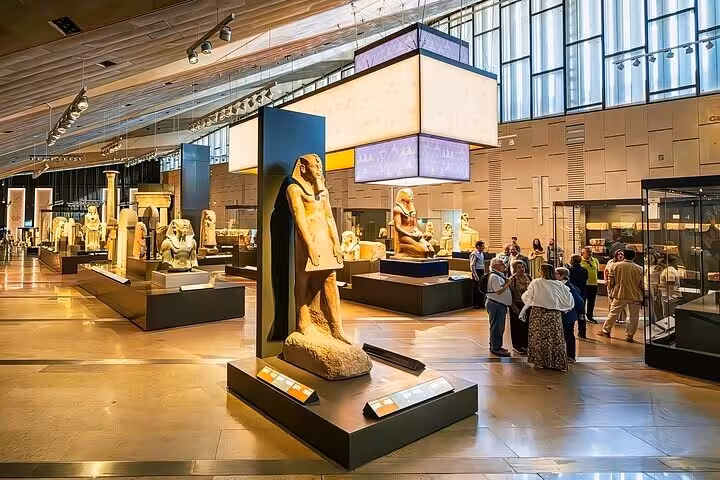 Grand Egyptian Museum main gallery with statues and exhibits, guided half-day Cairo tour with lunch and entry tickets