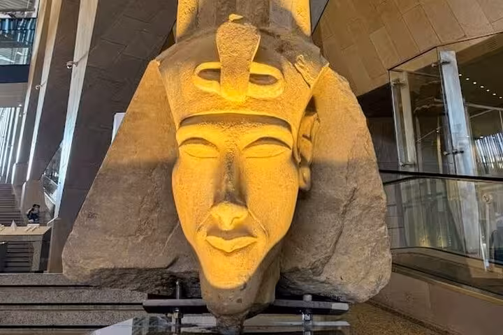 Colossal pharaoh stone head sculpture in the Grand Egyptian Museum lobby on half-day Cairo tour with tickets