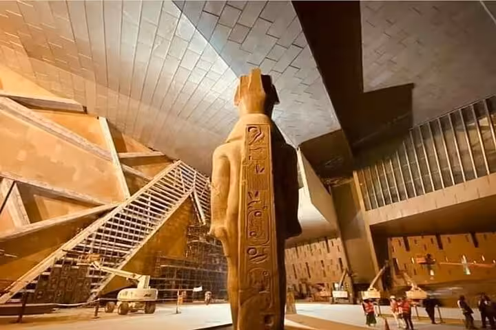 Colossal pharaoh statue inside Grand Egyptian Museum Cairo, modern hall view for QR ticket visit