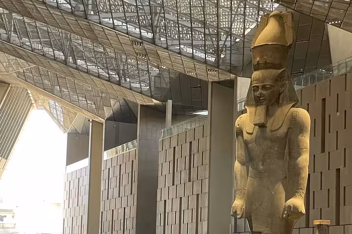 Grand Egyptian Museum interior with towering pharaoh statue under modern glass roof on private Cairo tour