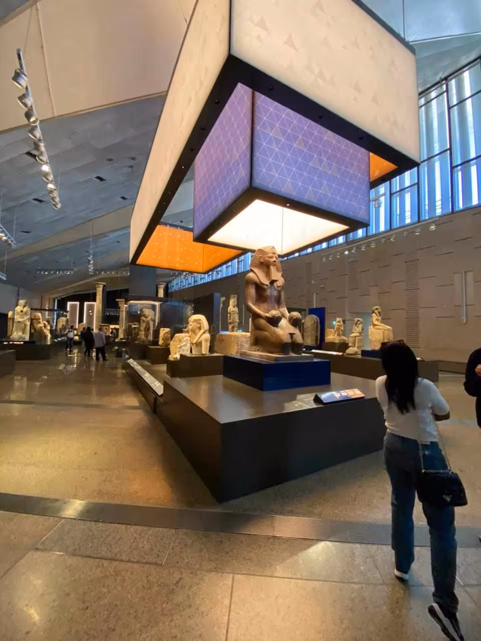 Grand Egyptian Museum gallery with pharaonic statue displays, part of full-day Giza Pyramids and lunch tour