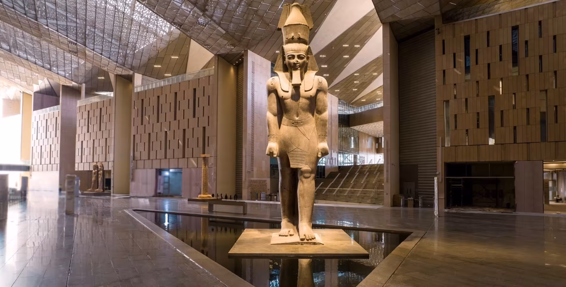 Colossal ancient Egyptian pharaoh statue in the grand atrium of the Grand Egyptian Museum, Giza