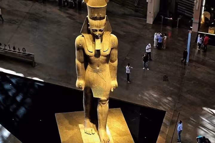 Colossal ancient Egyptian statue inside the Grand Egyptian Museum, highlight of Giza Pyramids tour