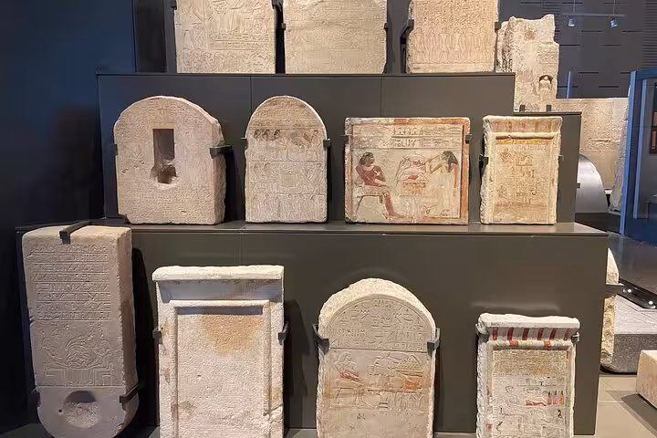 Ancient Egyptian stelae and carved reliefs on display at the Grand Egyptian Museum, Giza day tour with lunch