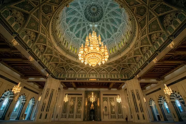 Stunning Grand Mosque interior with massive chandelier and ornate dome ceiling on Muscat cultural tour Oman