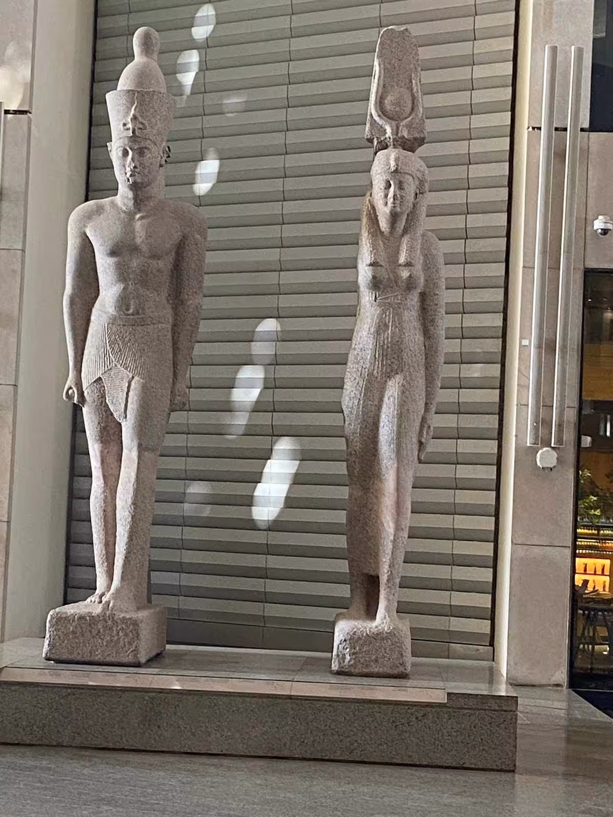 Twin granite statues at the Grand Egyptian Museum entrance hall, featured on a Giza Pyramids full-day tour