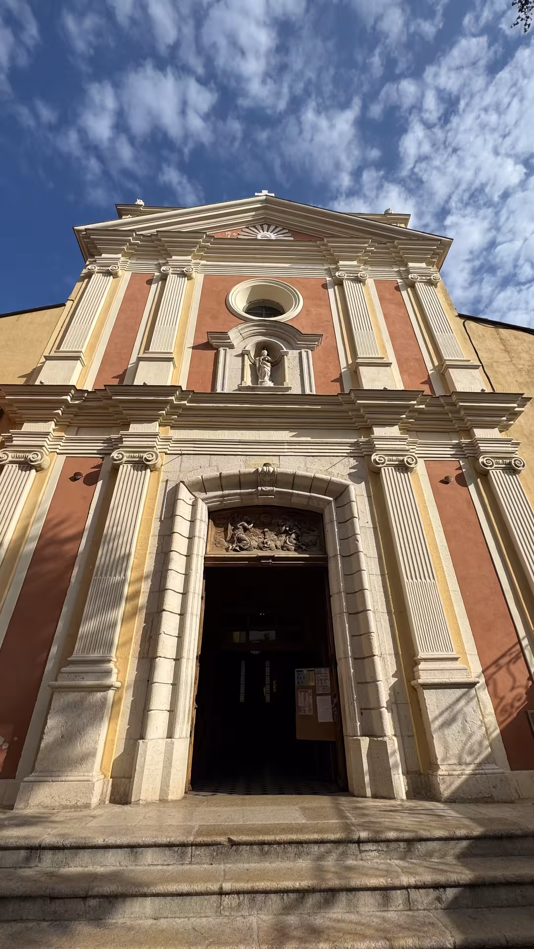 Baroque church facade with red and cream stone columns in Grasse, French Riviera