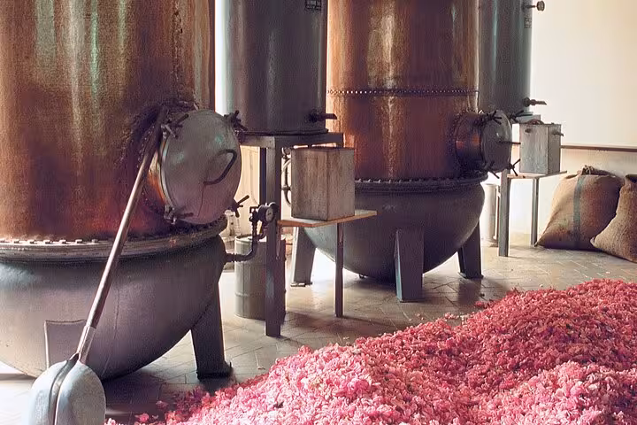 Rose petals and copper distillation vats inside a traditional Grasse perfume factory in Provence