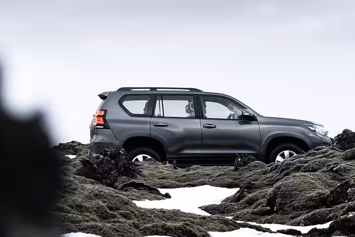 Dark gray Toyota Land Cruiser SUV navigating rocky terrain for private airport transfer
