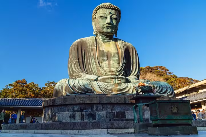 The Great Buddha of Kamakura under a clear blue sky, a highlight of the Tokyo to Kamakura private tour.