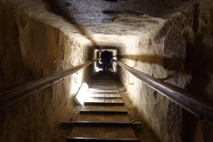 Descending the narrow tunnel and stairs inside the Great Pyramid of Giza on a customized Cairo day tour