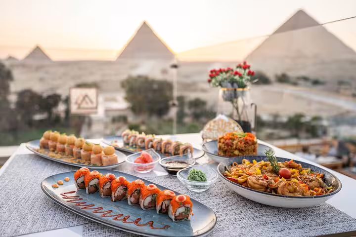 Lunch spread at Great Pyramid Inn rooftop with sushi and hot dishes overlooking Giza Pyramids, Cairo