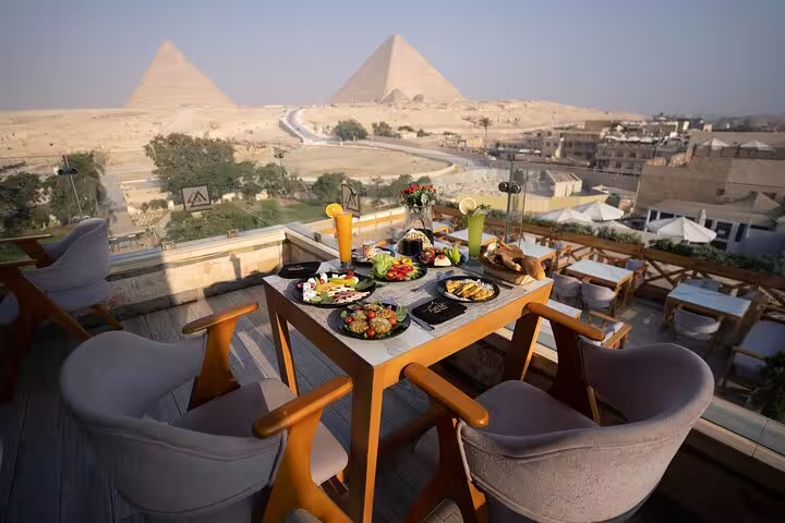 Great Pyramid Inn rooftop lunch spread with fresh dishes and panoramic Giza Pyramids view, Cairo Egypt