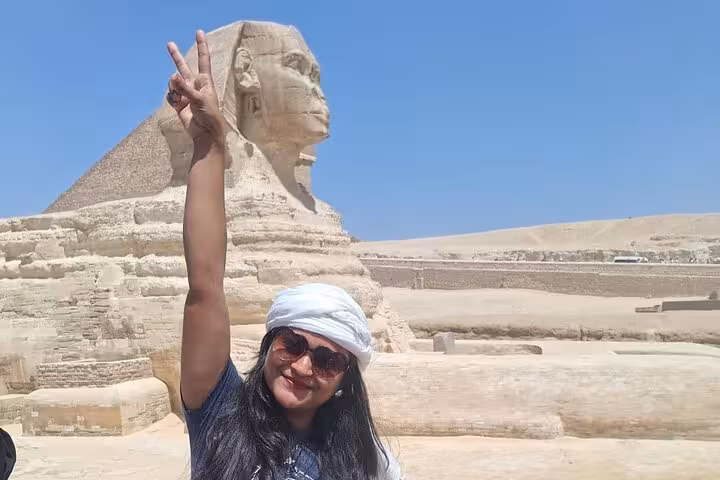 Visitor celebrates in front of the Great Sphinx, capturing the essence of Egypt's historical allure on exclusive tour.