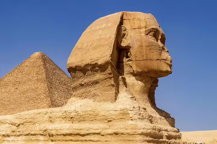 Close-up of the Great Sphinx with a Giza pyramid behind, highlight of Cairo Airport layover tour in Egypt