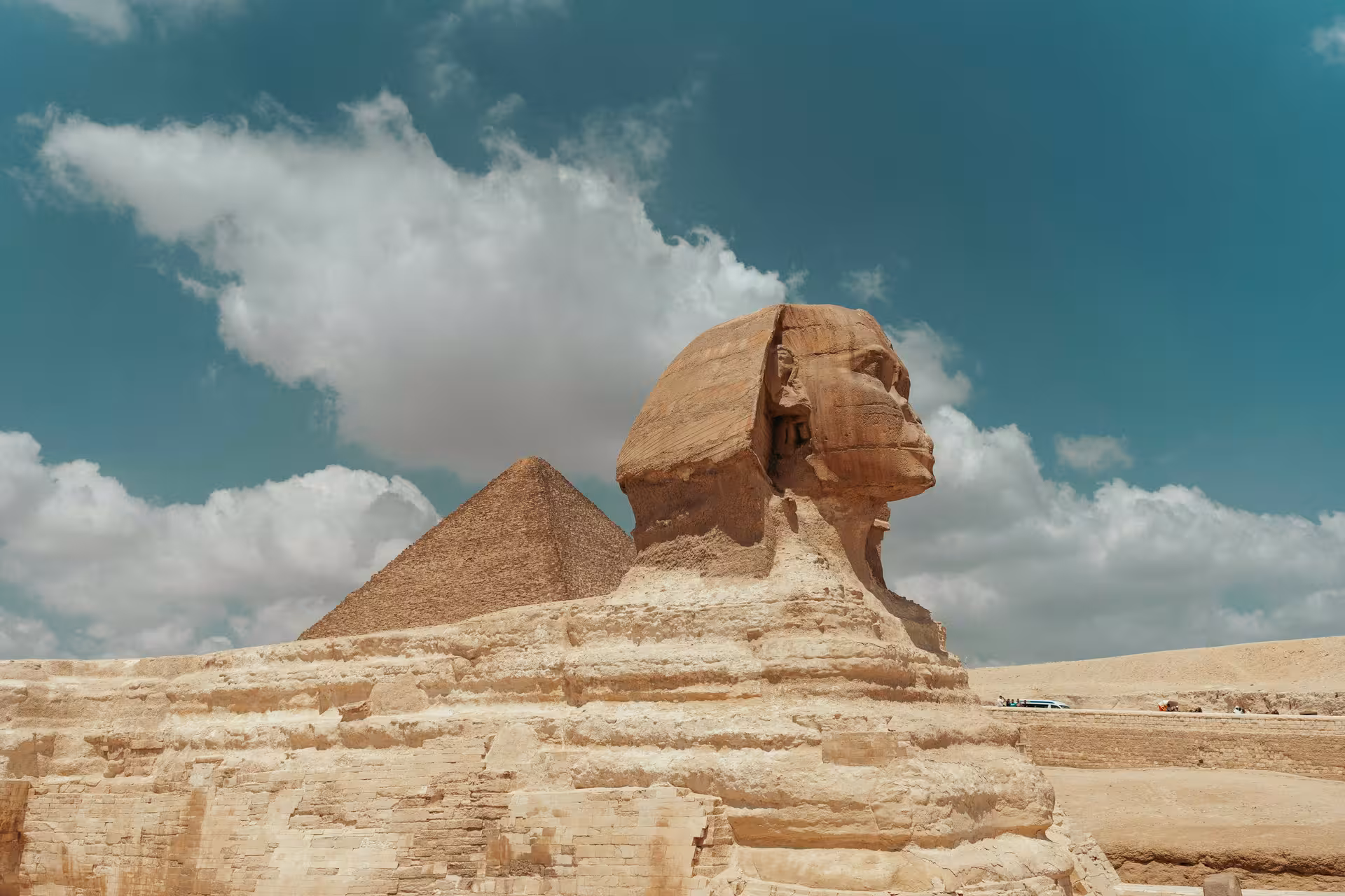 Great Sphinx of Giza with pyramid in background under blue sky, Egypt