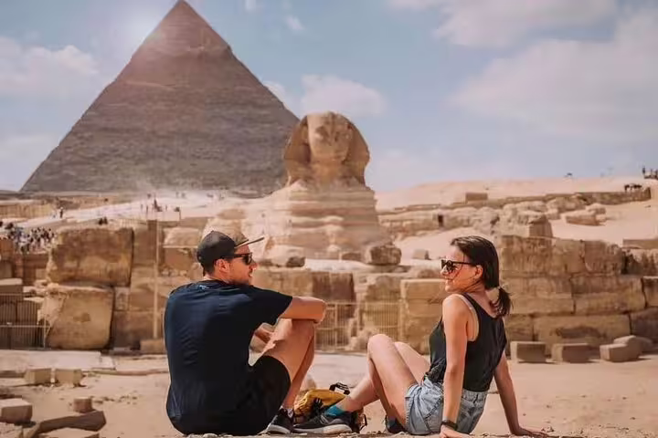Tourists relaxing near the Great Sphinx and Giza Pyramid on a Cairo day tour by bus from Sharm El Sheikh