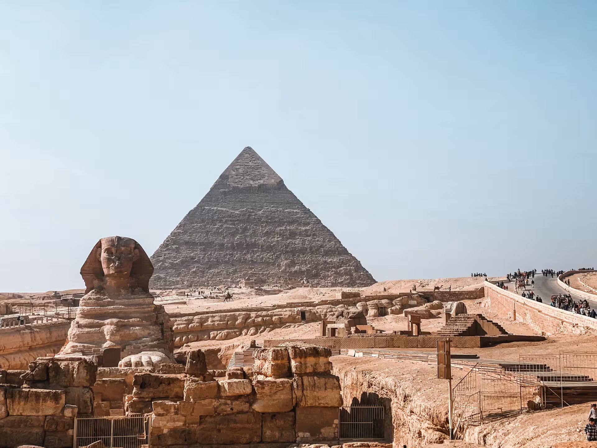 Great Sphinx and Pyramid of Khafre at Giza Plateau, Egypt, with tourists and desert landscape