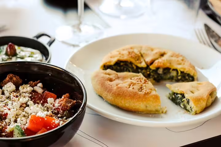 Spinach pie, Greek salad and tzatziki served after Athens cooking class, ready for rooftop dinner with Acropolis view