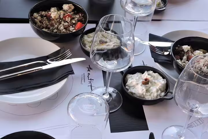 Rooftop dinner spread after Greek cooking class in Athens, mezze plates and wine with Acropolis view