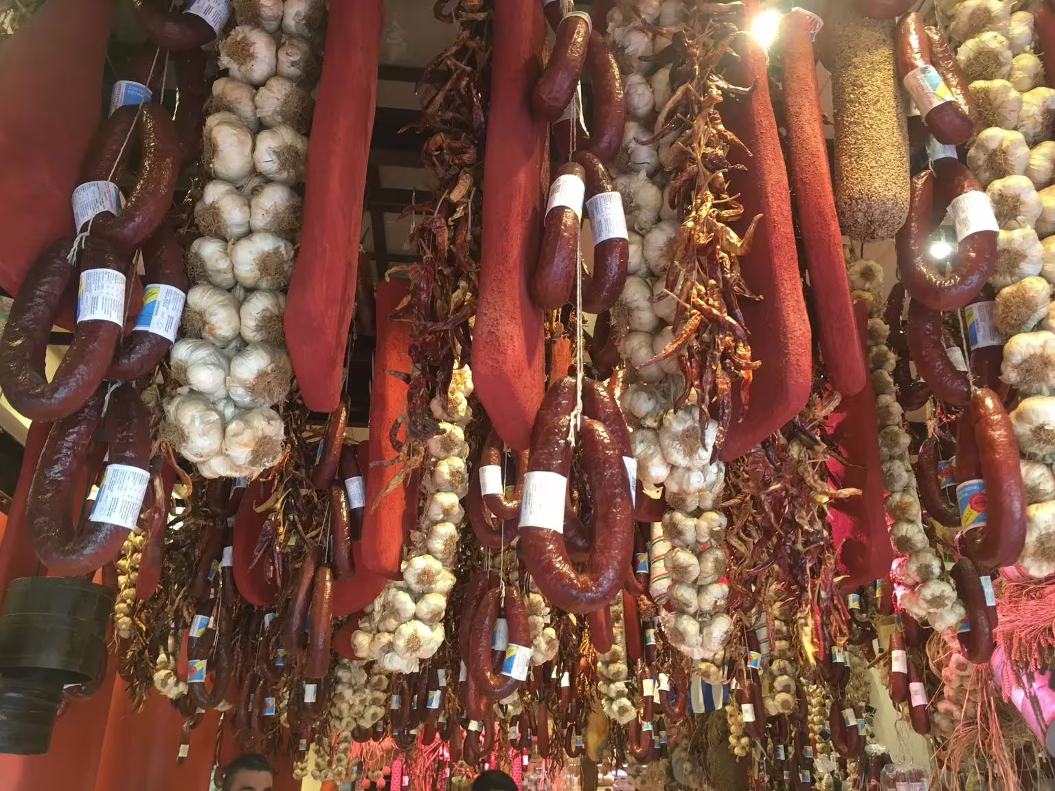 Hanging Greek cured sausages, garlic braids and dried peppers at Athens Central Market food tour stop