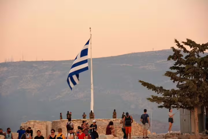 Greek flag flying above the Acropolis hill, Athens, on Viator Exclusive Acropolis tour with museum and dinner