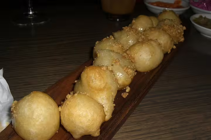 Greek loukoumades honey puffs served on a wooden board, a sweet tasting on the Athens food tour