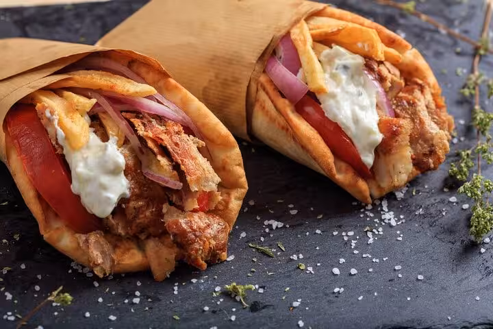 Fresh Greek souvlaki pita wraps with tzatziki and onions, street food on an Athens by Night walking tour