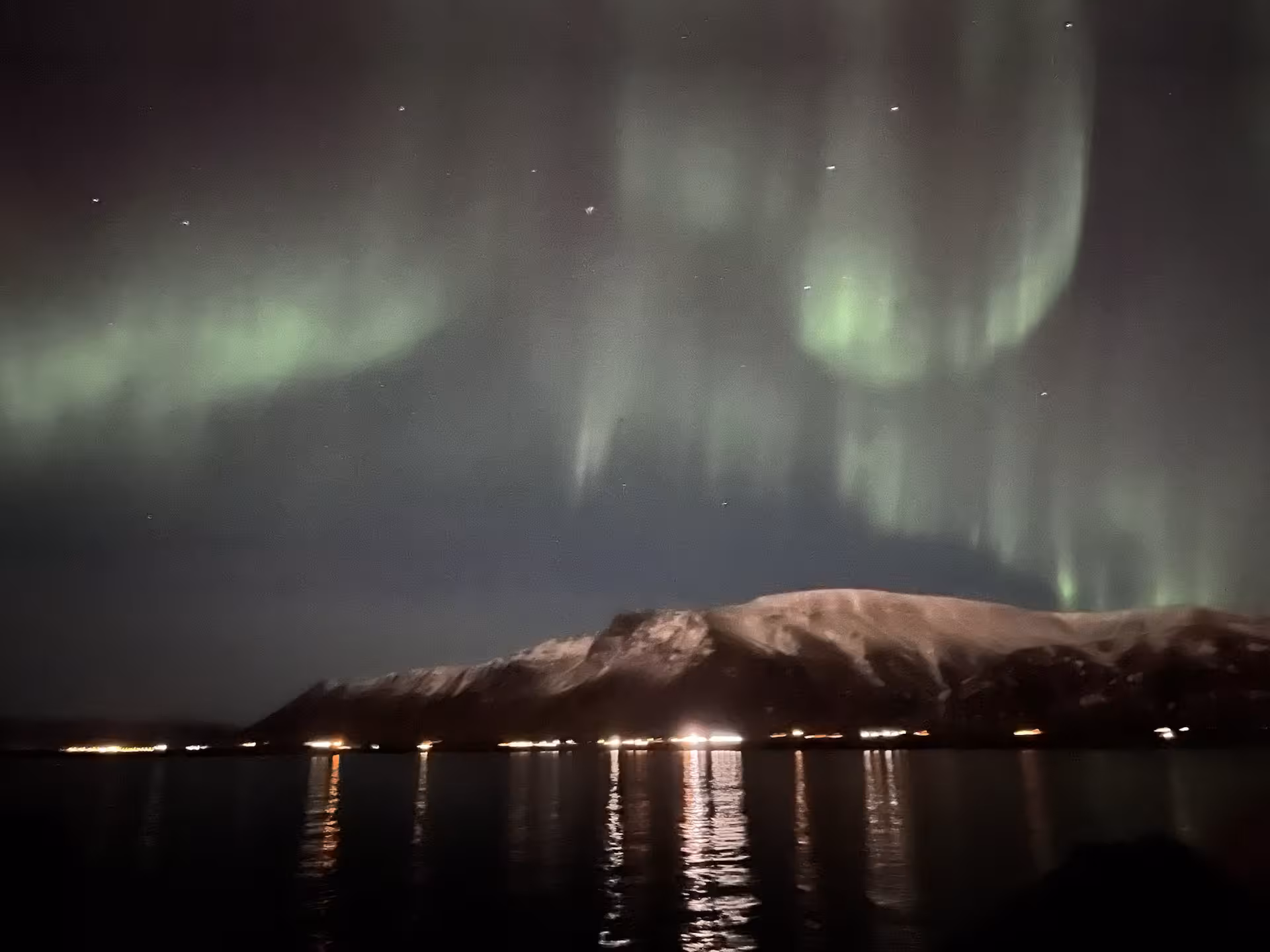 Bright green Aurora Borealis stretching across the dark Icelandic sky