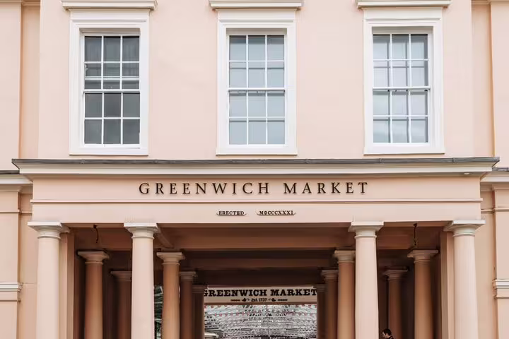 Greenwich Market entrance with neoclassical columns and inscription 'Erected MDCCCXXXI' on pink facade