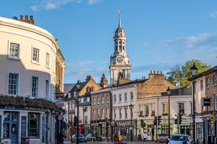 Historic Greenwich town centre with Georgian buildings and St Alfege Church clock tower on a sunny day
