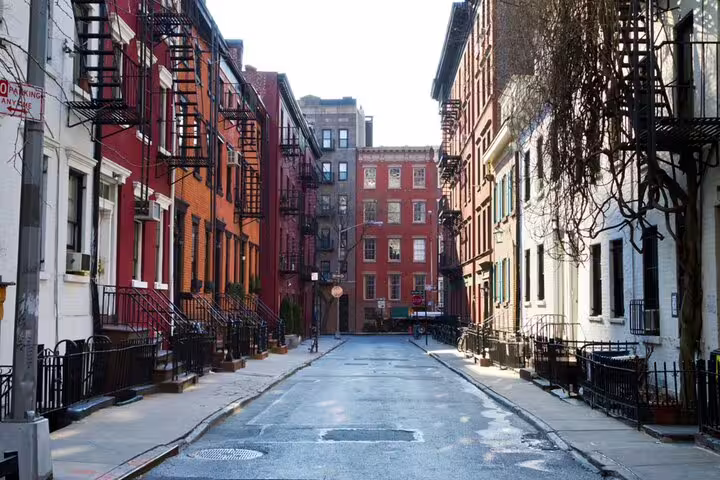 Historic brick buildings lining a quiet cobblestone street in Greenwich Village, New York City