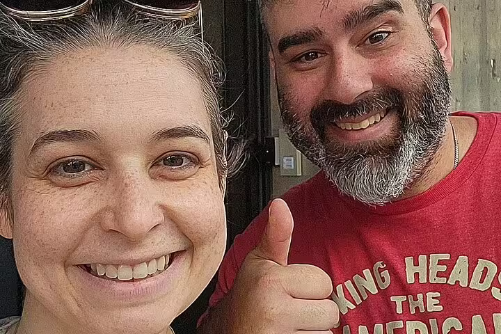 Smiling couple taking a selfie, man in red shirt giving thumbs up on Greenwich Village tour