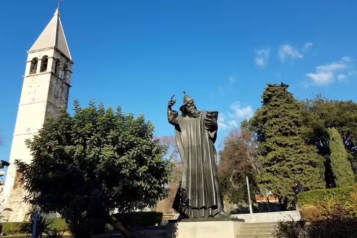 Statue of Gregory of Nin in Split with bell tower, popular stop on Split cruise ship tour to Trogir