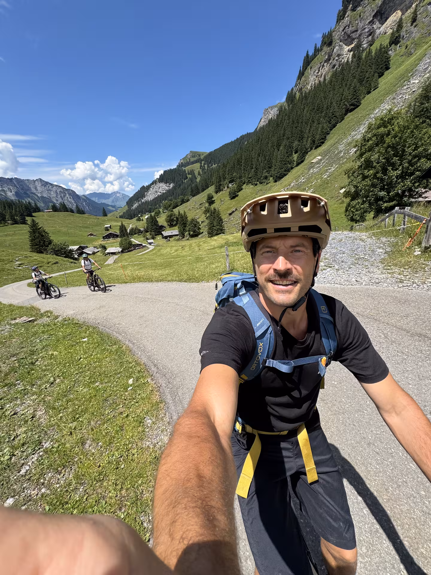 E-bike rider selfie on Griesalp mountain road with alpine meadows, a highlight of the UNESCO valley tour