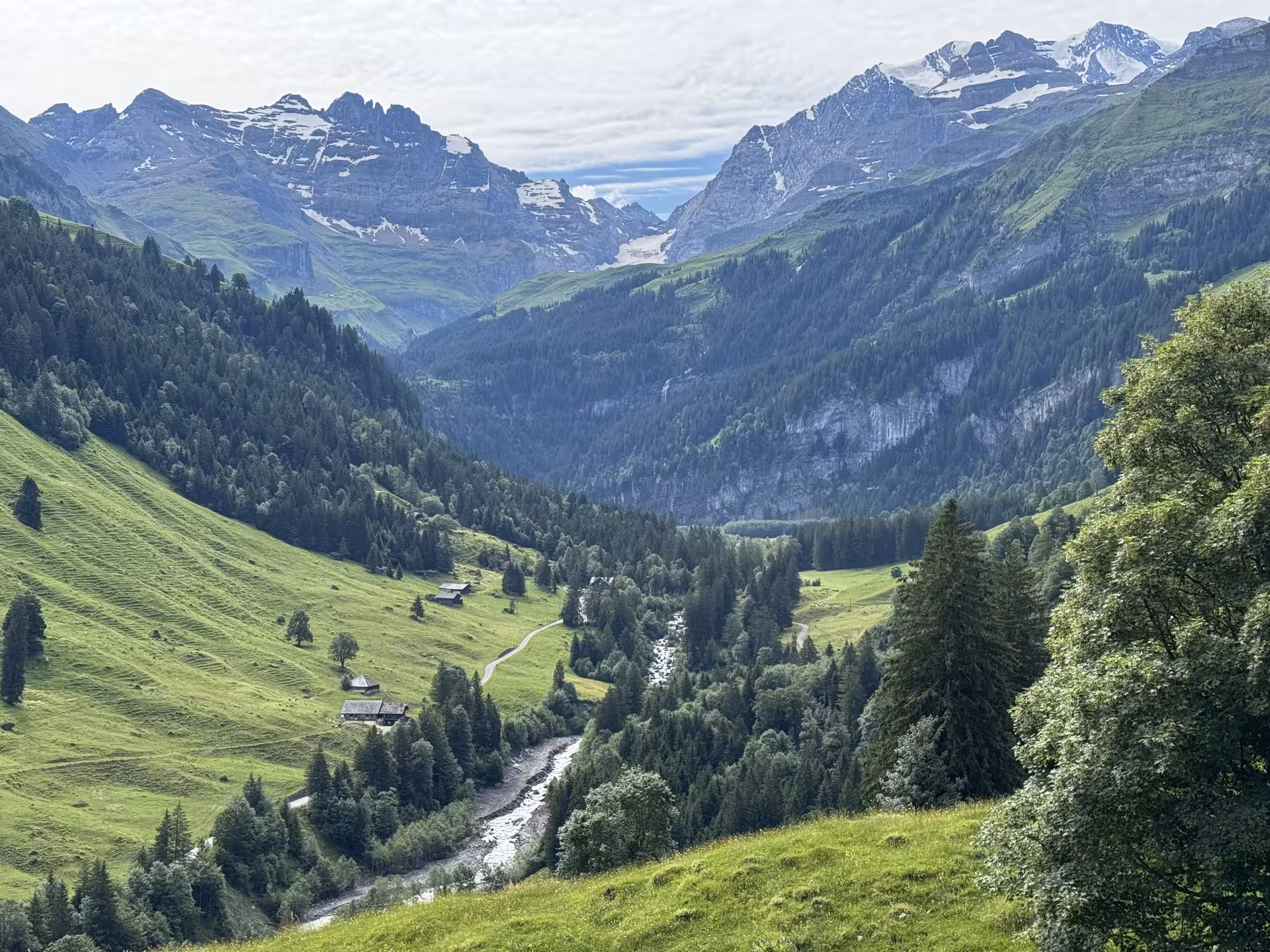 Panoramic Griesalp UNESCO alpine valley with river, chalets and snowcapped peaks on Swiss E-bike tour