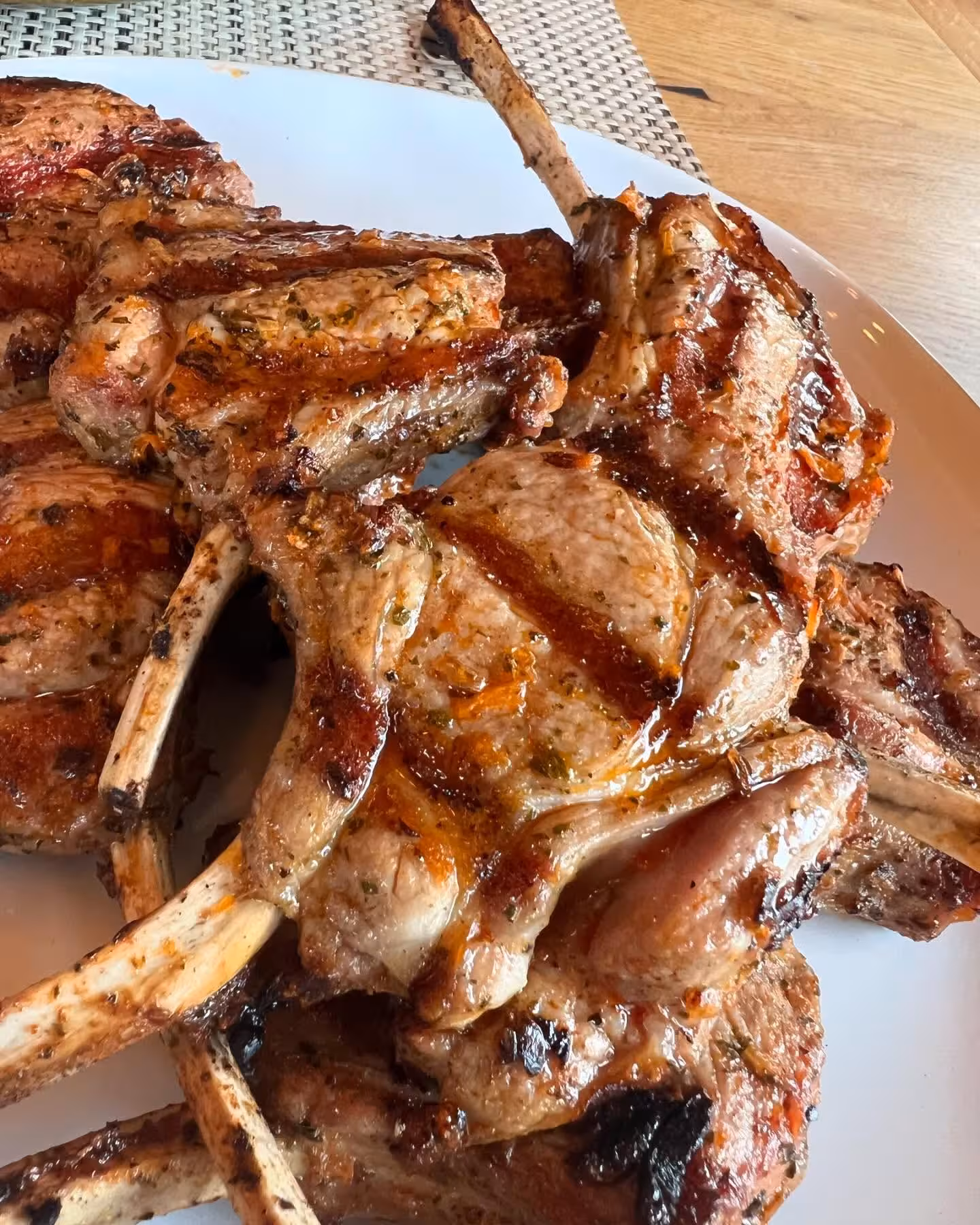 Juicy herb-marinated grilled lamb chops served as gourmet food pairing during a lakeside wine tasting tour