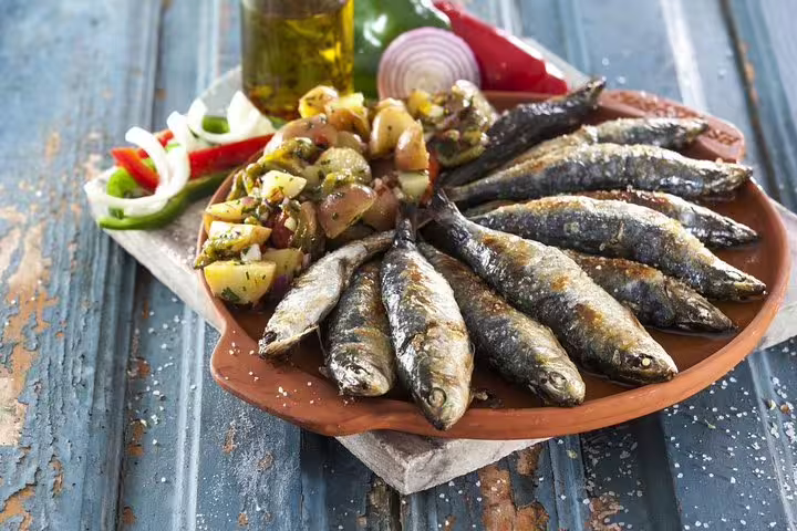 Delicious grilled sardines with roasted potatoes and vegetables, a traditional Portuguese dish on the 7-day tour from Lisbon.